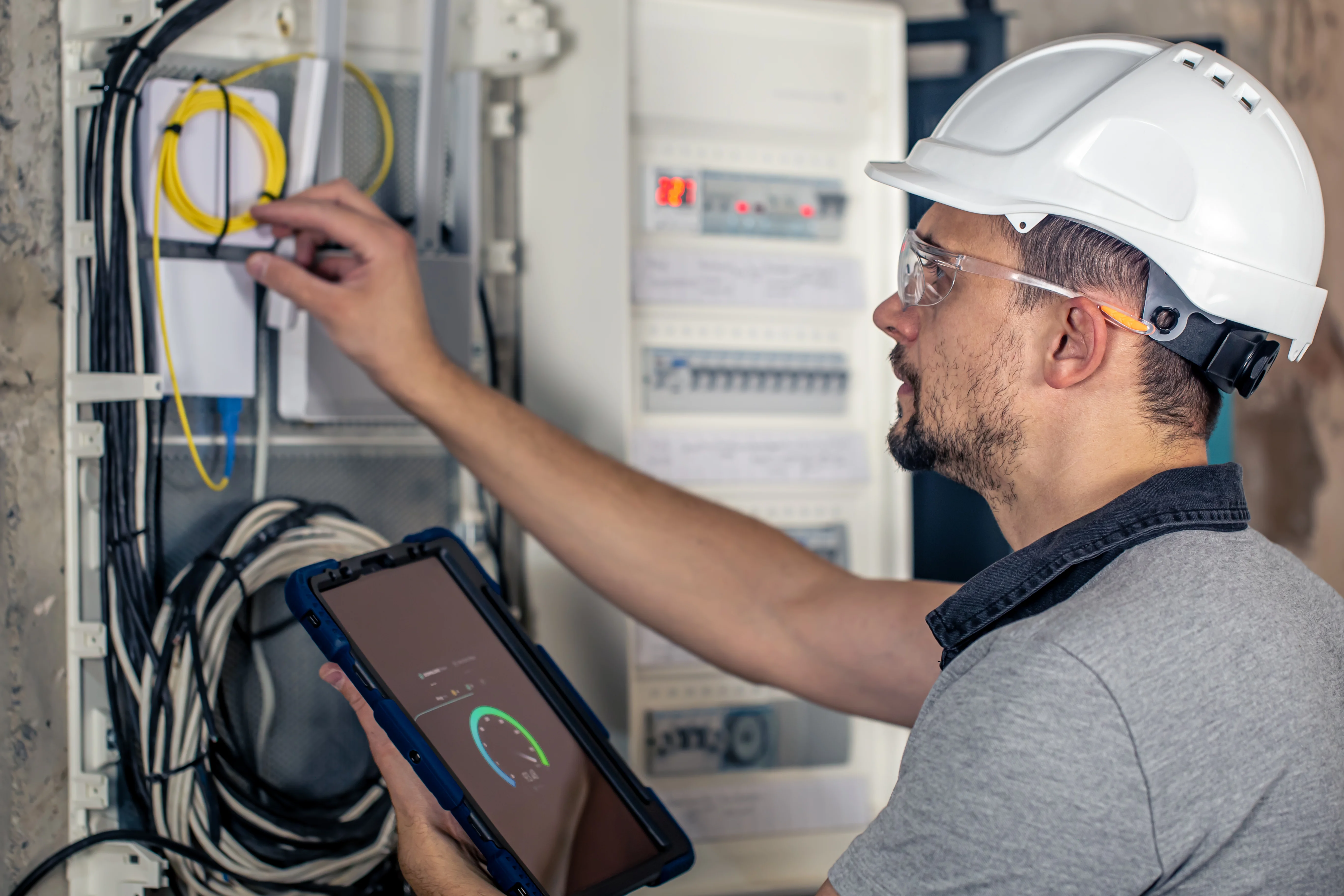 Technician working on energy storage equipment with digital monitoring systems